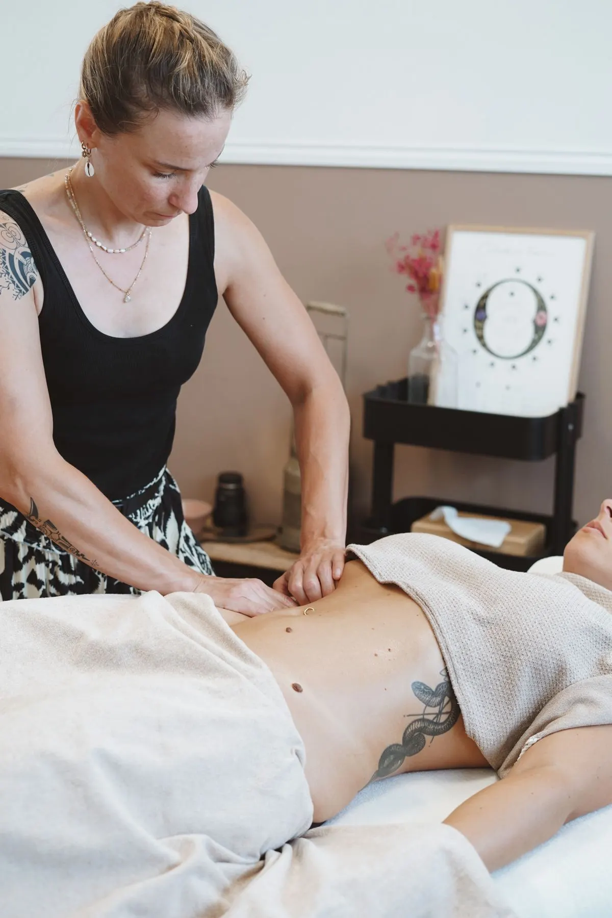 Drainage lymphatique à Soustons : Anaïs, concentrée, les mains sur le ventre d'une cliente
